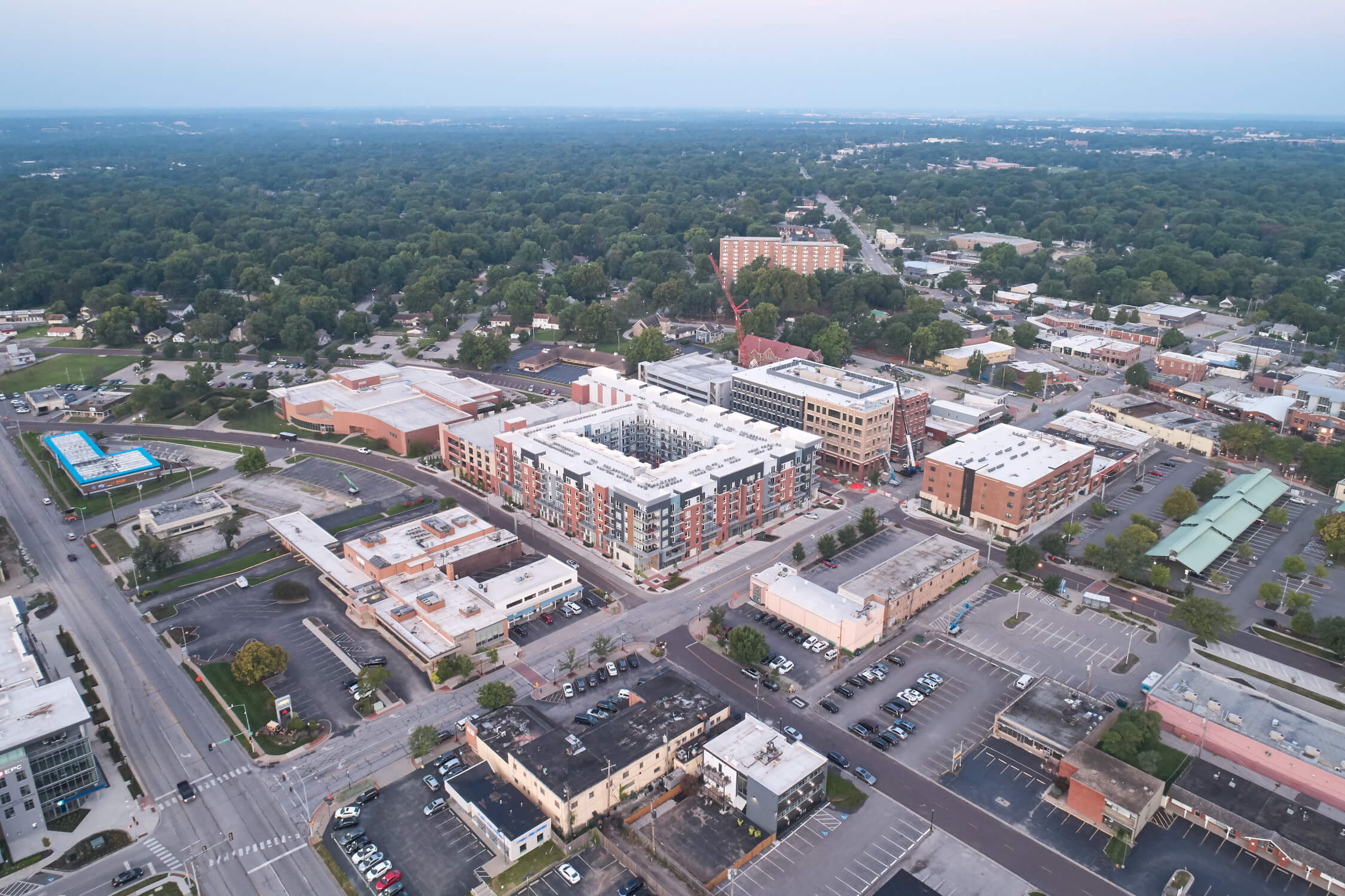 An aerial image shows the heart of historic downtown Overland Park, Kansas, including The Vue multifamily development and the site of a new Hunt Midwest luxury apartment community next door.