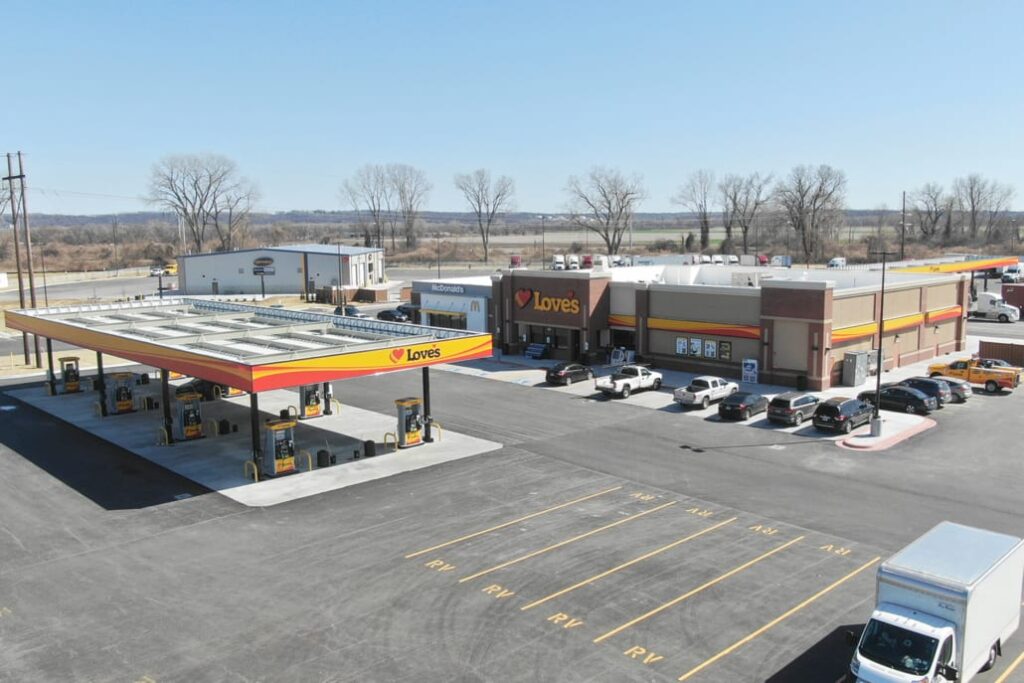 Modern Love’s travel stop with large fuel canopy, multiple pumps, parking spaces, and McDonald’s next door.
