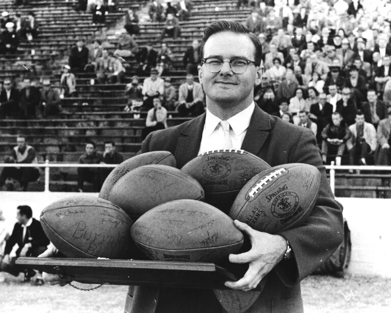 Lamar Hunt holding footballs.